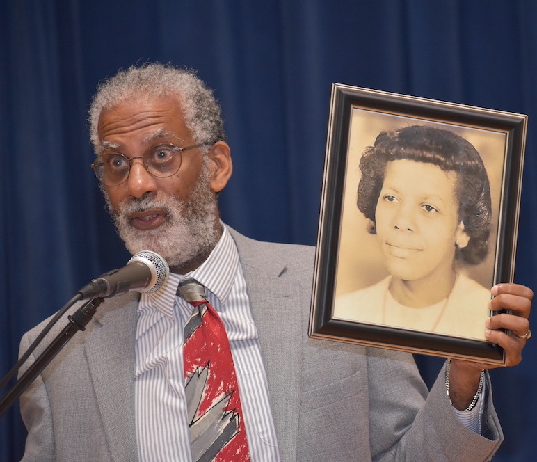 Gregory Cooke holding an old framed photograph of his mother, Becky
